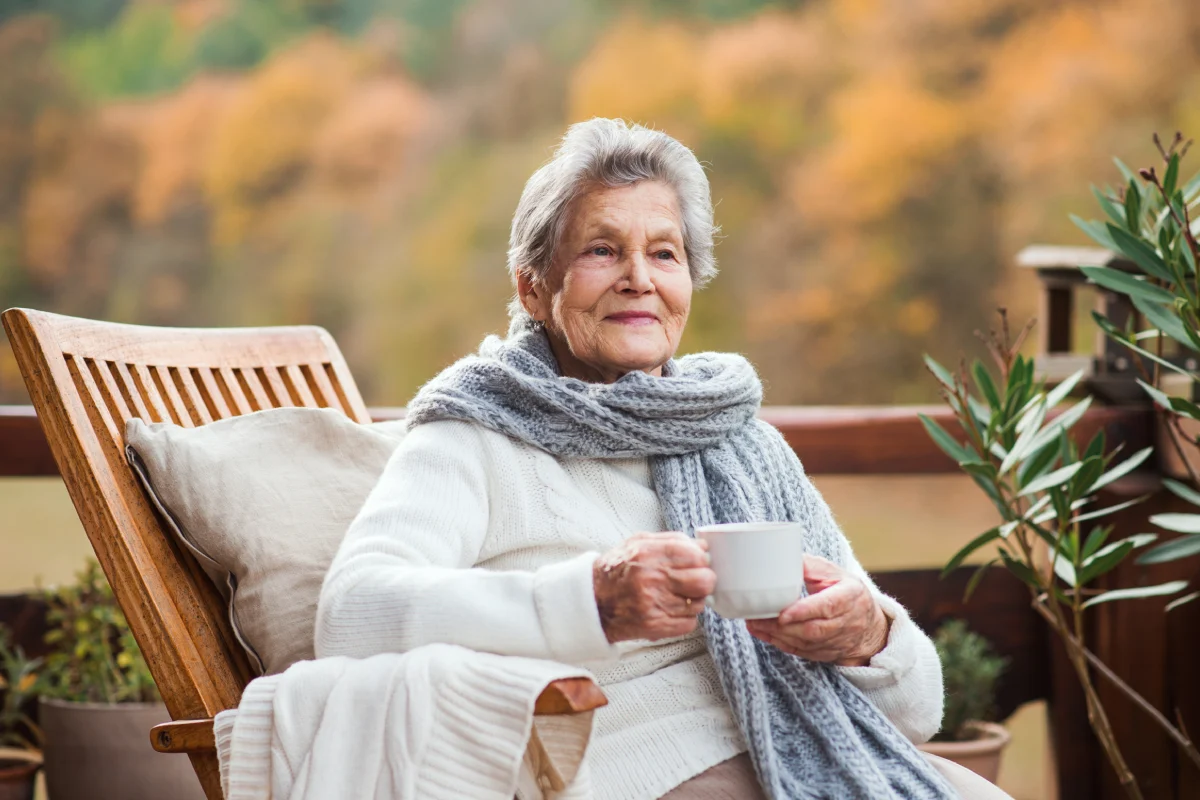 Senior woman relaxing and drinking coffee on patio